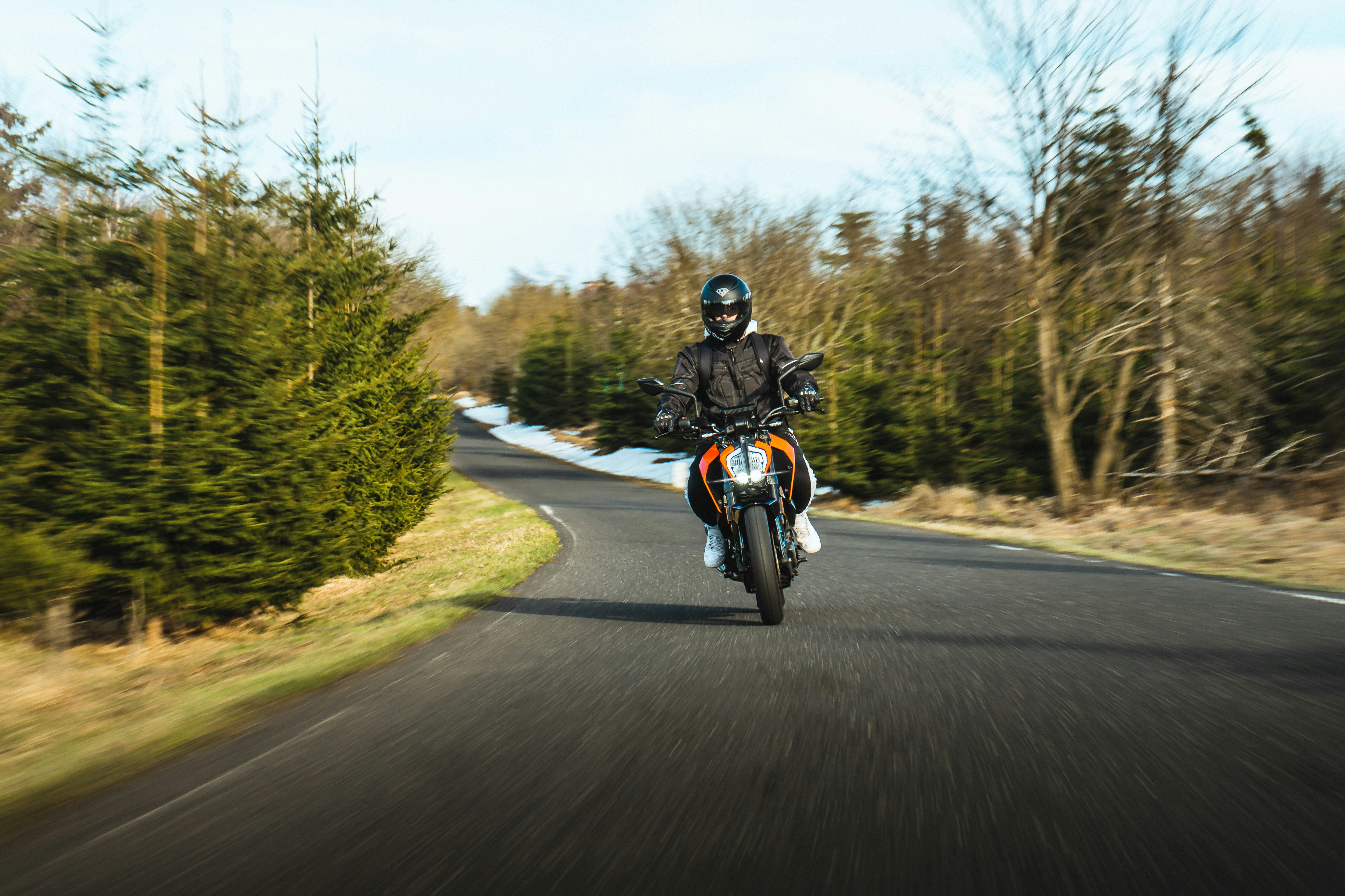 man riding motorcycle on road during daytime